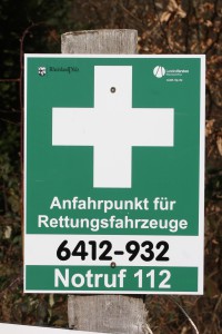 Solche Schilder (weißes Kreuz auf grünem Grund) markieren die Rettungspunkte. Der Rettungspunkt 6412-932 liegt an der L387 zwischen Otterberg und Höringen (Einfahrt Betonstraße).
